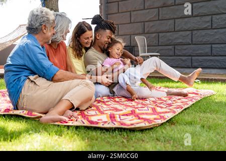 A happy multigenerational family spending quality time outdoors, sharing love and laughter on a sunny day. Stock Photo