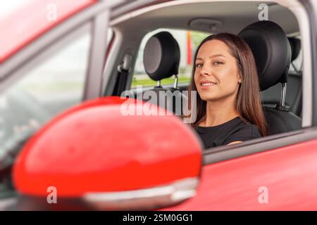 Beautiful woman sits in the driver's seat of car half-turned Stock ...