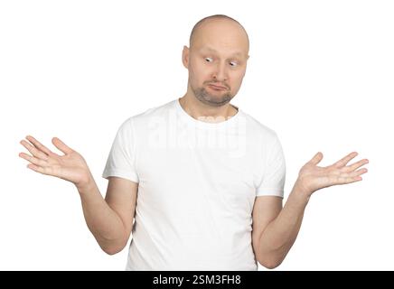 A bald Caucasian man with a short beard is wearing a white t-shirt and shrugging with raised hands, displaying a confused expression. Stock Photo
