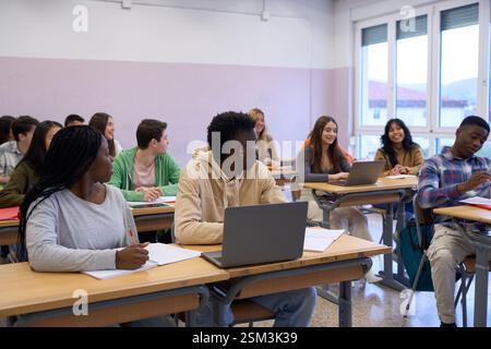 Multiethnic students studying together in modern classroom Stock Photo