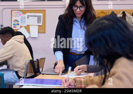 Professor helping students studying in classroom at university institute Stock Photo