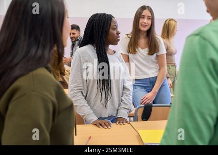University students chatting together in classroom after lesson Stock Photo