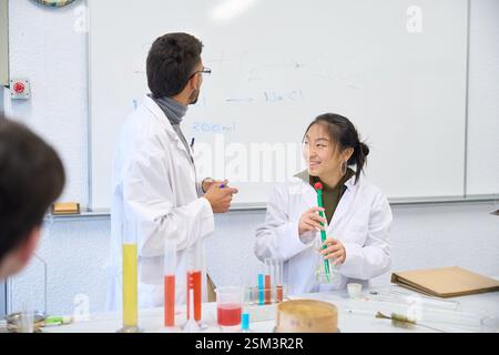 Chemistry students collaborating on experiment in university lab Stock Photo