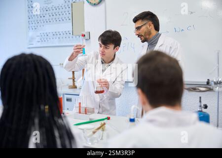 Chemistry students and teacher performing experiment in laboratory Stock Photo