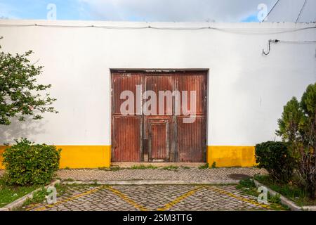 exterior of a building with a rusty corrugated iron door Stock Photo
