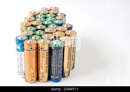 November, 25, 2023; Madrid, Spain. Number of batteries of various brands and colors, piled up on a white background. Stock Photo
