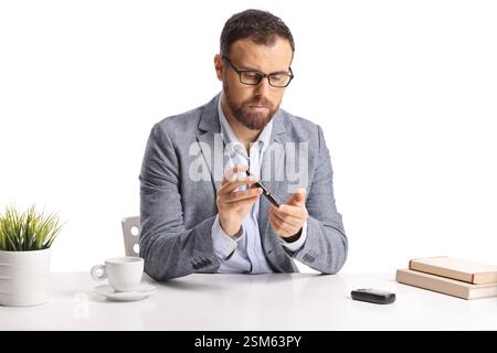Man using a lancing device for blood glucose monitoring isolated on white background Stock Photo