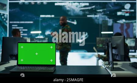Army IT expert in control center collecting real time battlefield data, process satellite surveillance imagery for successful military defense mission. Using green screen isolated display. Camera B. Stock Photo