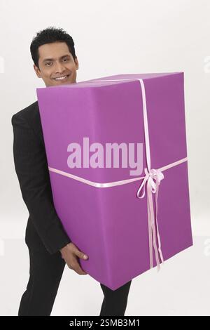 Businessman holding big gift box in both hands MR#703T Stock Photo