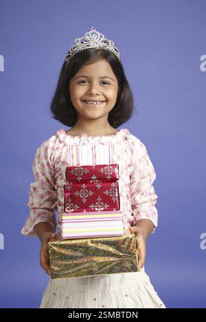 Eight year old girl holding five present boxes in both hand MR#703U Stock Photo