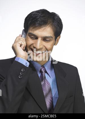 South Asian Indian executive man talking on mobile phone MR Stock Photo