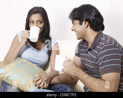 Young man and woman holding hands looking at each other MR#702V, 702U Stock Photo
