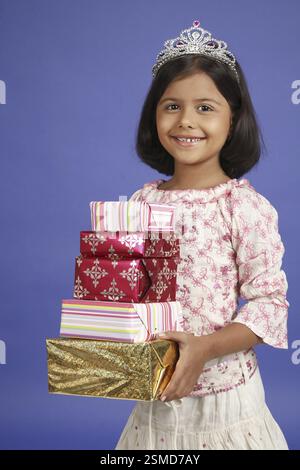 Eight year old girl holding five present boxes in both hand MR#703U Stock Photo