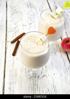 Jelly airy apple in wineglasses, red apples and cinnamon on a background of wooden boards Stock Photo