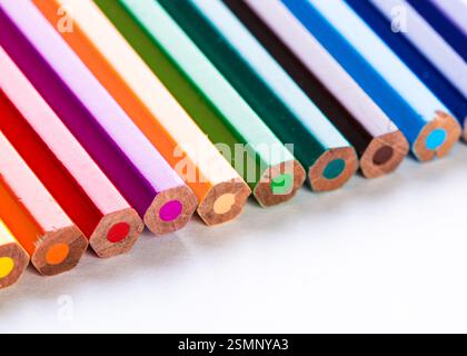 Colorful collection of sharpened colored pencils arranged neatly on a white surface Stock Photo