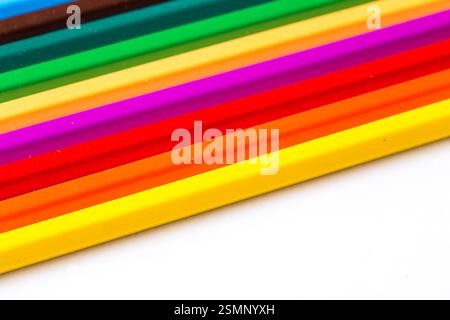 Vibrant colored pencils arranged in a line showcasing a variety of hues on a plain background Stock Photo