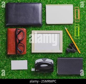 Office supplies arranged on green grass background creating a vibrant workspace scene Stock Photo