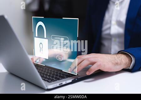 Man using a laptop with a security concept on the screen. Icons and graphics of a padlock interface for entering the security key. Stock Photo