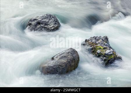 Background with bolders in a river with smooth water, long exposure shot Stock Photo