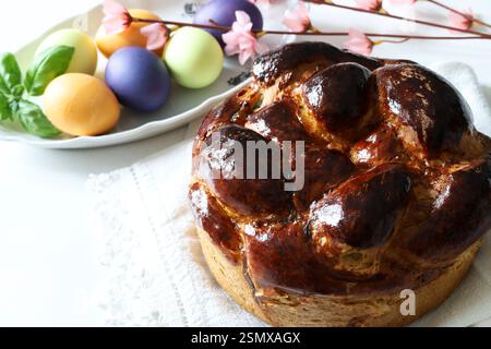 Traditional sweet bread and colorful eggs for Easter on background. Easter holiday concept. Copy space. Stock Photo
