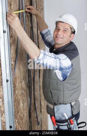 man is measuring insulation walls Stock Photo
