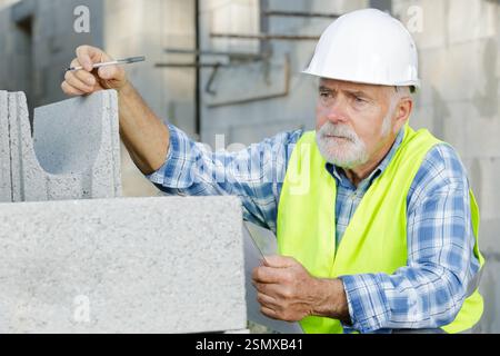 senior worker is checking cement outdoors Stock Photo