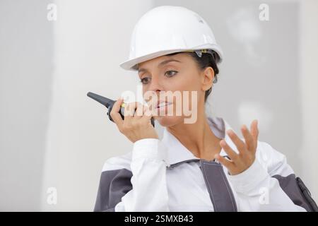 female builder using walkie talkie Stock Photo