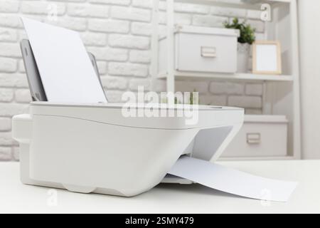 Modern printer in a well-organized workspace printing documents on crisp white paper Stock Photo