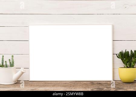 Blank canvas placed on rustic wooden table among potted plants in a bright room Stock Photo