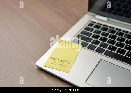 Sticky note with the word "password 123456" on a laptop keyboard. Data protection, password strength concept. Stock Photo