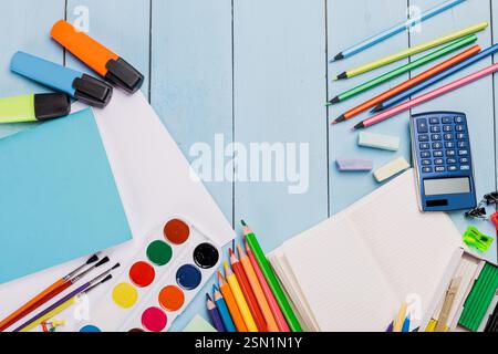 Collection of colorful art supplies and tools neatly arranged on a blue wooden surface displaying creativity and organization Stock Photo