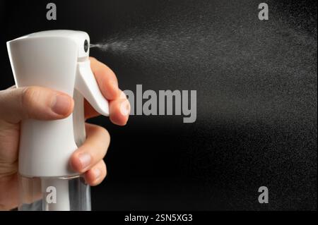 Water spray jet on black background from plastic bottle close up view Stock Photo