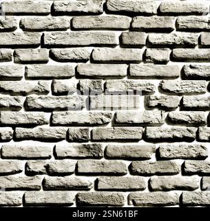 Gray brick wall forming a textured background with light and shadow Stock Photo