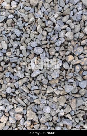 Pile of rocks is on the ground. The rocks are gray and are scattered all over the ground Stock Photo