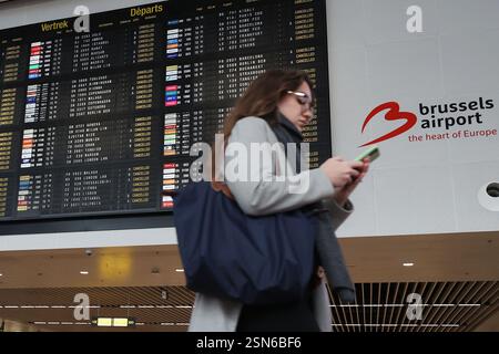 (250213) -- BRUSSELS, Feb. 13, 2025 (Xinhua) -- A woman walks past a flight information board at the departure hall of Brussels Airport in Zaventem, Belgium, Feb. 13, 2025. Tens of thousands of people marched through central Brussels, Belgium, on Thursday to protest against planned government reforms, as unions warned of further strike action unless policymakers reconsider their proposals. The demonstration brought parts of the capital to a standstill, halting traffic on key routes and disrupting public transport. Brussels Airport canceled 430 flights as ground operations were suspended, whi Stock Photo