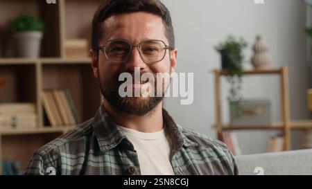 Portrait happy smiling carefree positive headshot Caucasian man male bearded guy in glasses health homeowner in own apartment smile looking at camera Stock Photo
