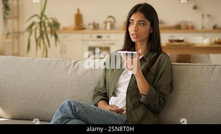 Muslim woman Arabian girl Islamic lady female talking mobile phone loudspeaker dictate talk speech speak to smartphone microphone call record audio Stock Photo