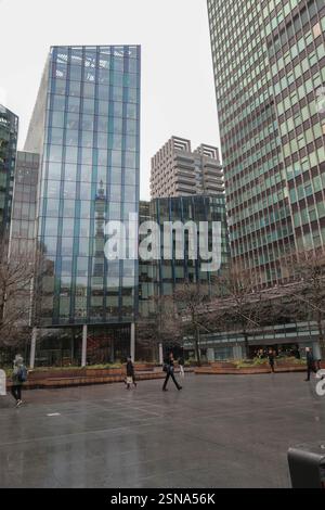 People walking across Triton Square in London in front of glass fronted office blocks Stock Photo