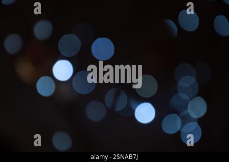 A blurry, out-of-focus image shows light circles of various shades of blue and light gray.  These are likely the light from various sources. Stock Photo
