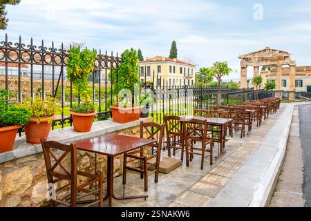 Empty tables at a sidewalk cafe alongside the Roman Agora in the historical Plaka area of Athens, Greece. Stock Photo