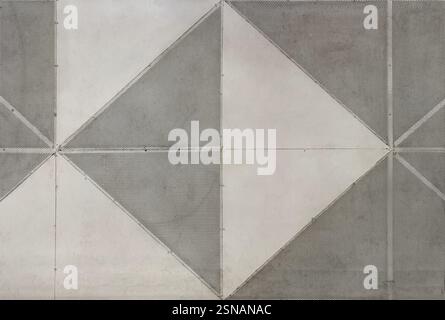 Perforated metal plate cut and arranged in diamond pattern. Grey and white metal plate joined to form a geometrical triangular and diamond shape Stock Photo