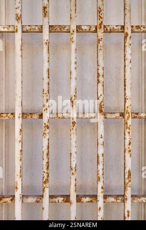 Old rusty grid in front of a dirty bright wall Stock Photo