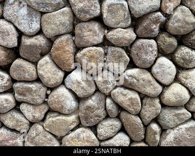 Close up of pebble stone wall as decorative material on landscape garden wall finishes. Cemented pebbles are good choice for quartz decoration in gard Stock Photo