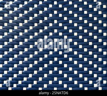 Close up of blue and white synthetic rattan or wicker weaving art in vertical stripes pattern. Rattan hand woven background seamless texture. Stock Photo