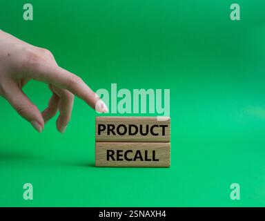 Product recall symbol. Concept words Product recall on wooden blocks. Beautiful green background. Businessman hand. Business and Product recall concep Stock Photo