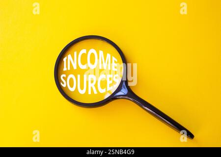 Income Sources symbol. Magnifying Glass with Concept word Income Sources. Beautiful yellow background. Business and Income Sources concept. Copy space Stock Photo