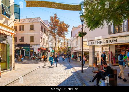 Pedestrians pass by shops selling duty free items on a holiday decorated Main Street, the main shopping street in the center of Gibraltar, UK. Stock Photo