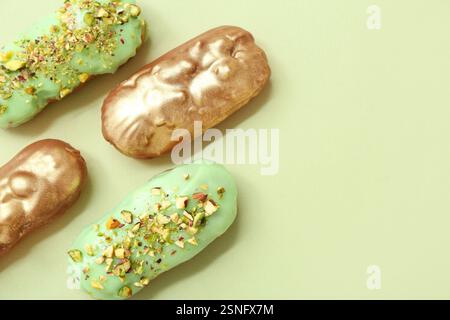 Composition with tasty glazed eclairs on color background Stock Photo