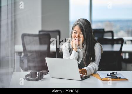 Asian woman professional using laptop computer sitting on sofa working ...