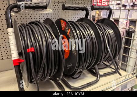 Bobruisk, Belarus - 10 February 2025: Several rolls of durable black wire are neatly organized on display in a hardware store. This showcases a variet Stock Photo